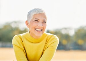 older woman with a youthful smile outside