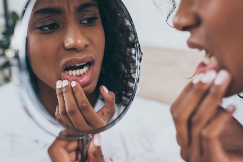 A woman looking in the mirror at her teeth